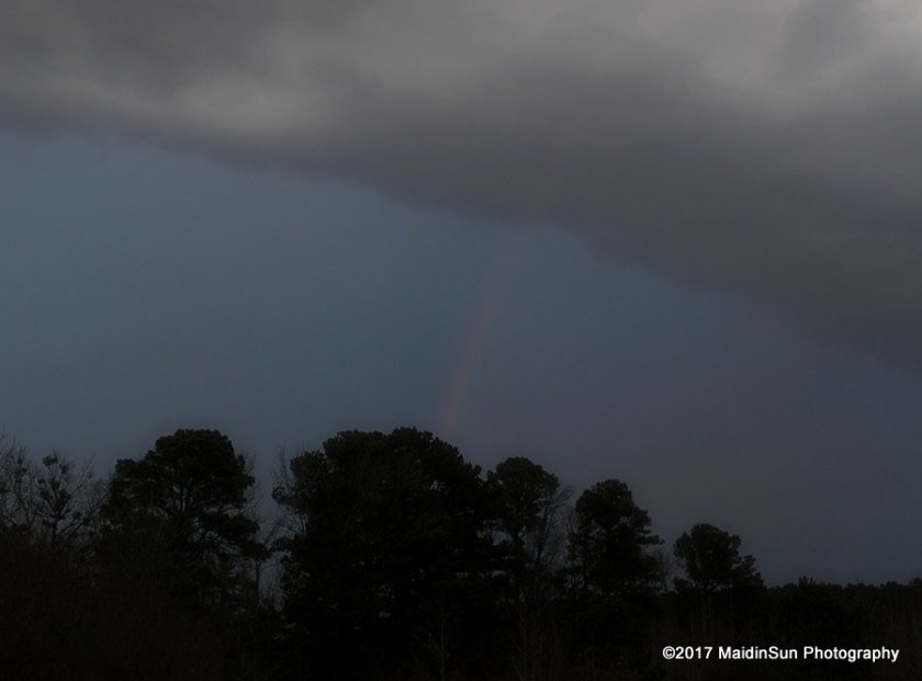 A faint rainbow at the edge of the storm front.